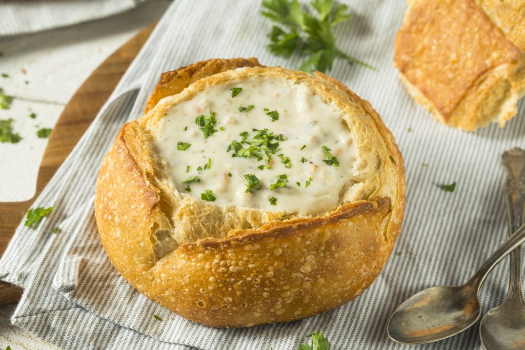 Clam chowder servido en plato blanco con pan, comida típica de Massachusetts