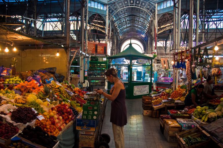 Visitantes recorriendo la feria de San Telmo con puestos de antigüedades y arte. Lugares imperdibles de Buenos Aires