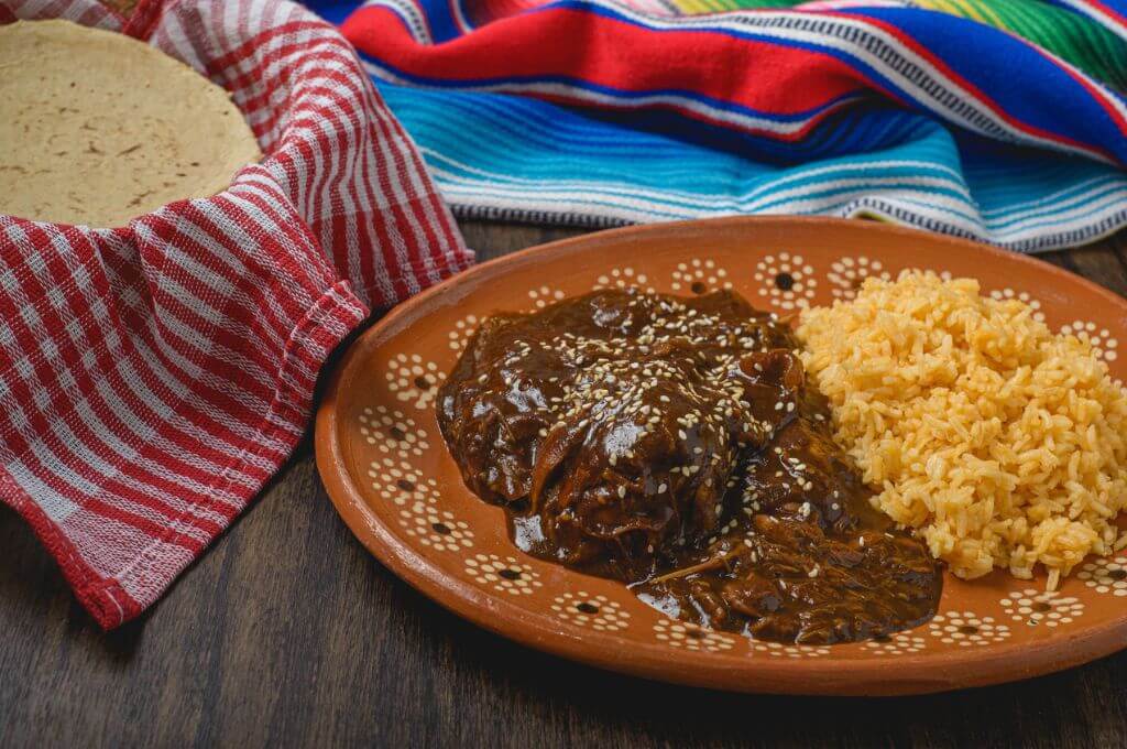 Plato de mole poblano acompañado de arroz y tortillas frescas en un restaurante típico de Puebla