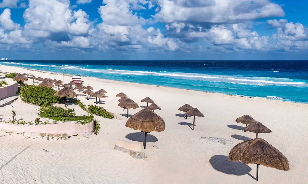 Qué hacer en Quintana Roo, Playa de Cancún con aguas turquesa y palmeras.