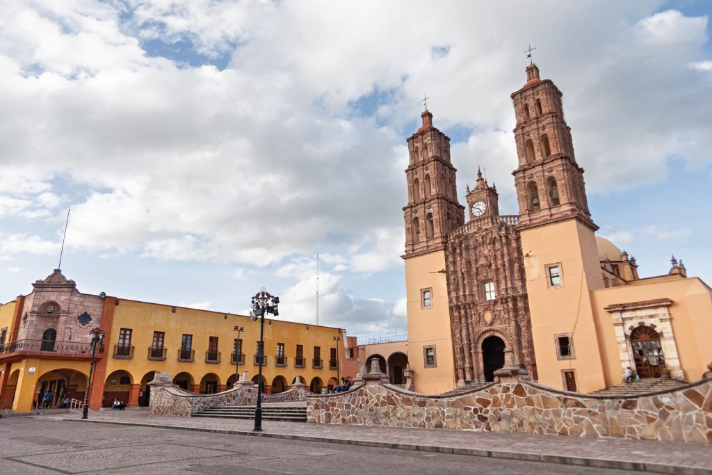 Plaza central de Dolores Hidalgo con iglesia y mural histórico visible, los mejores lugares para visitar en Guanajuato