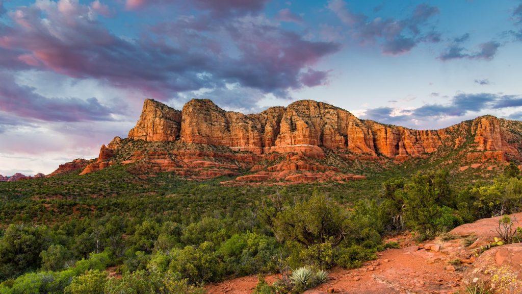 Rocas rojas iluminadas por el sol en Sedona, Arizona, con cielo azul despejado
