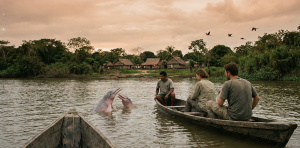 Fotografía realista de turistas en una canoa de madera observando delfines rosados (bufeos) en un río de la Amazonía, Beni, Bolivia, durante un viaje de turismo.